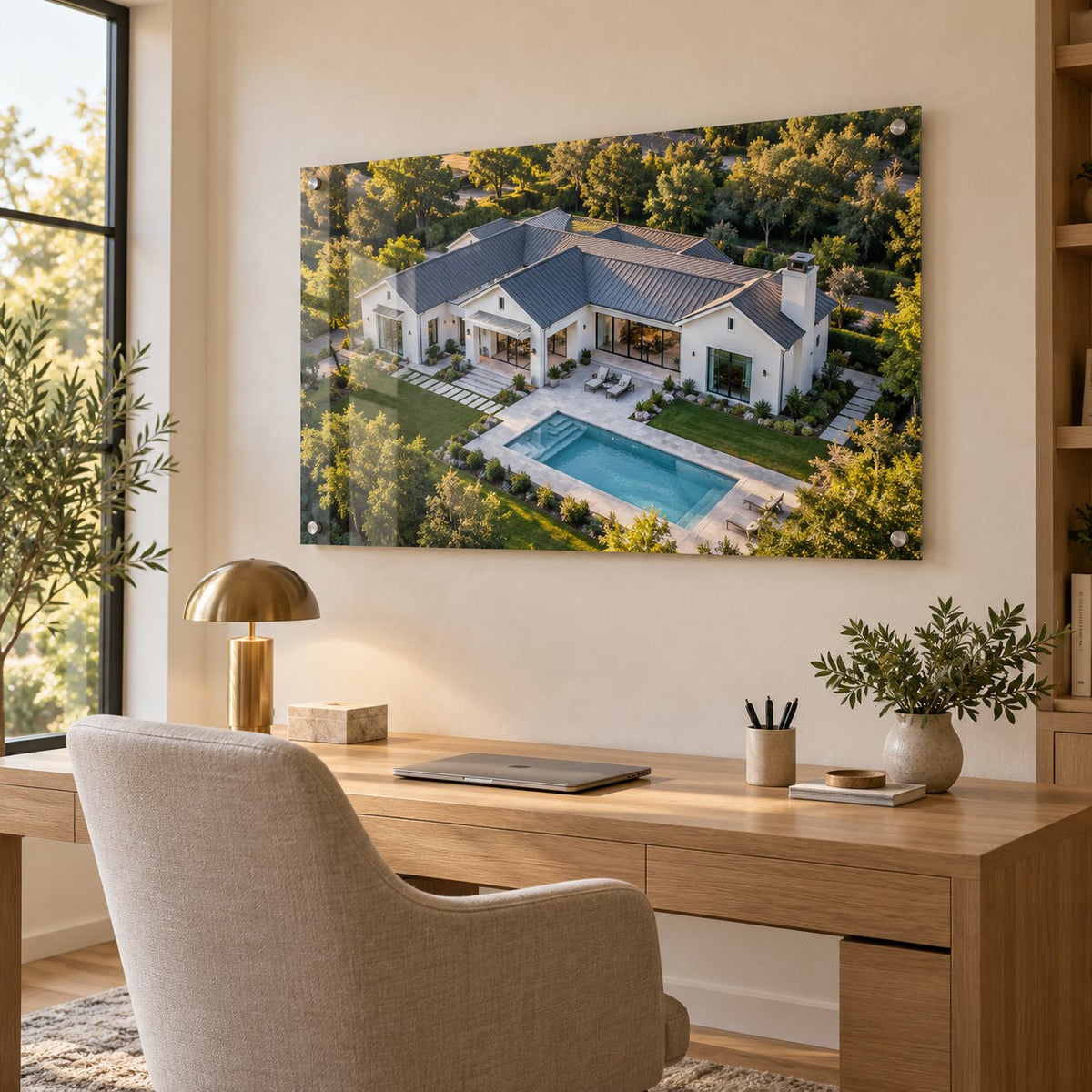 Aerial drone photo of a modern farmhouse with a pool printed on clear acrylic and hung in a home office