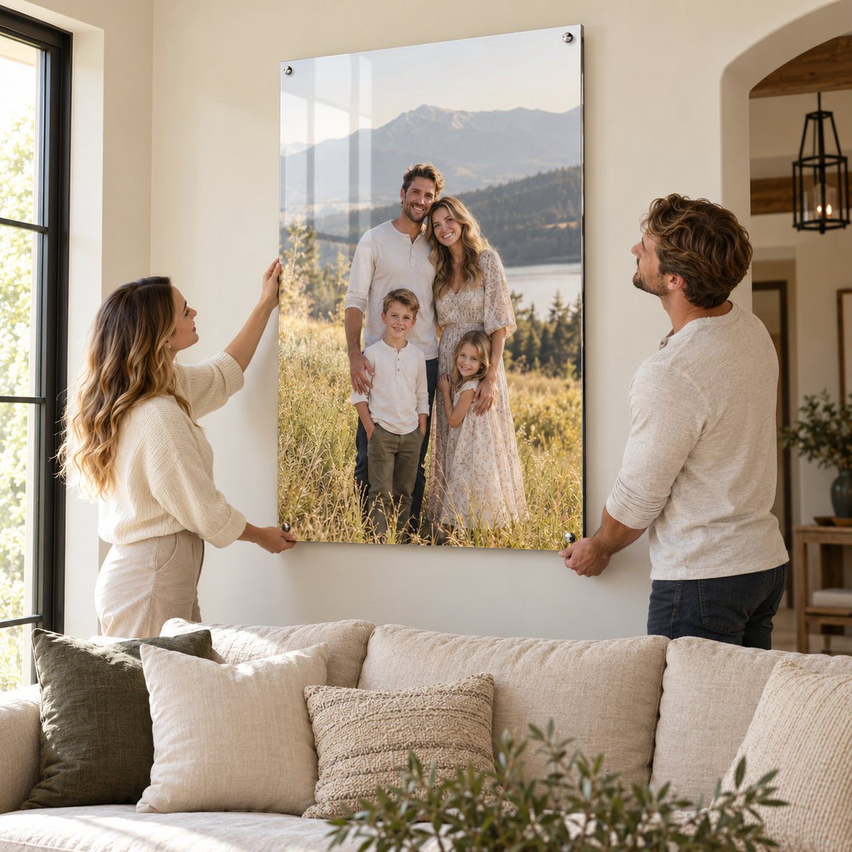 Couple hanging a large acrylic family photo print on a living room wall