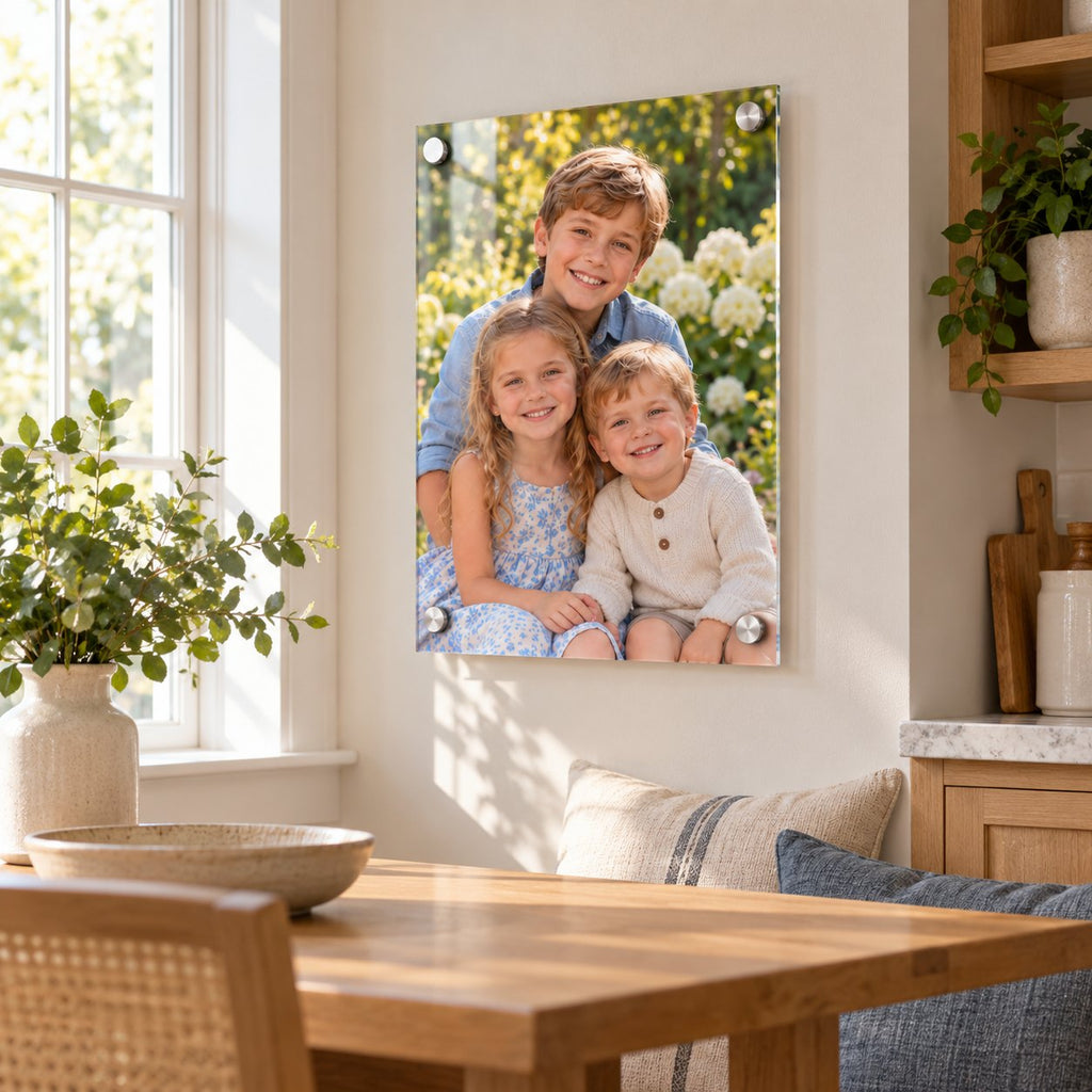Photo of three grandchildren printed on clear acrylic and hung on a kitchen wall by a sunny window