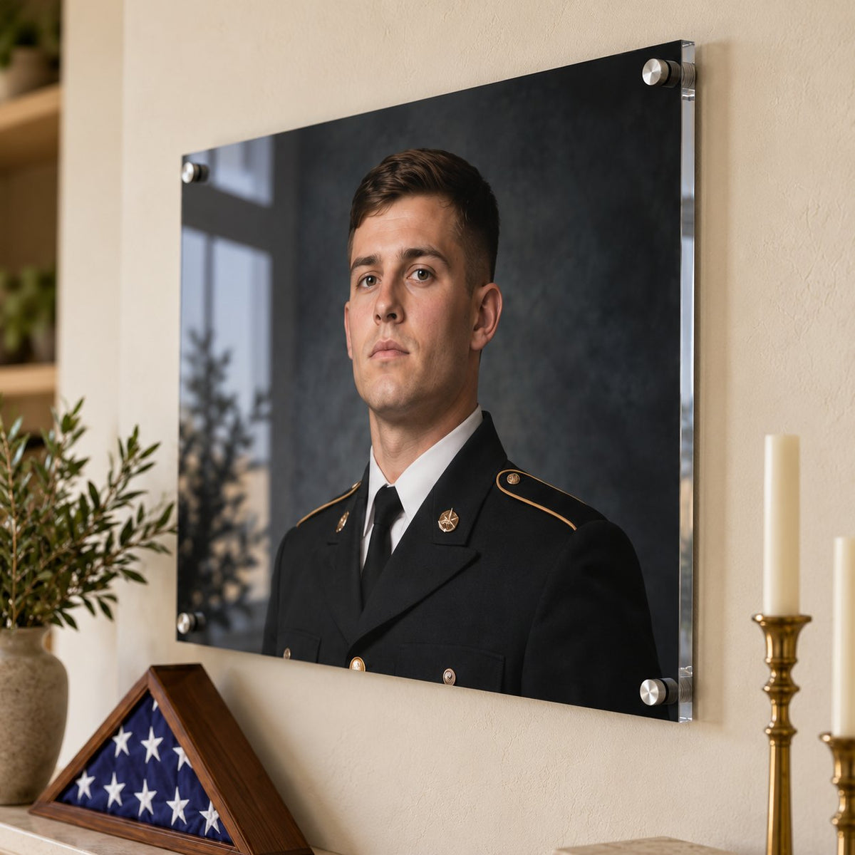 Close view of a military dress-uniform portrait acrylic print with silver standoffs beside a folded flag case