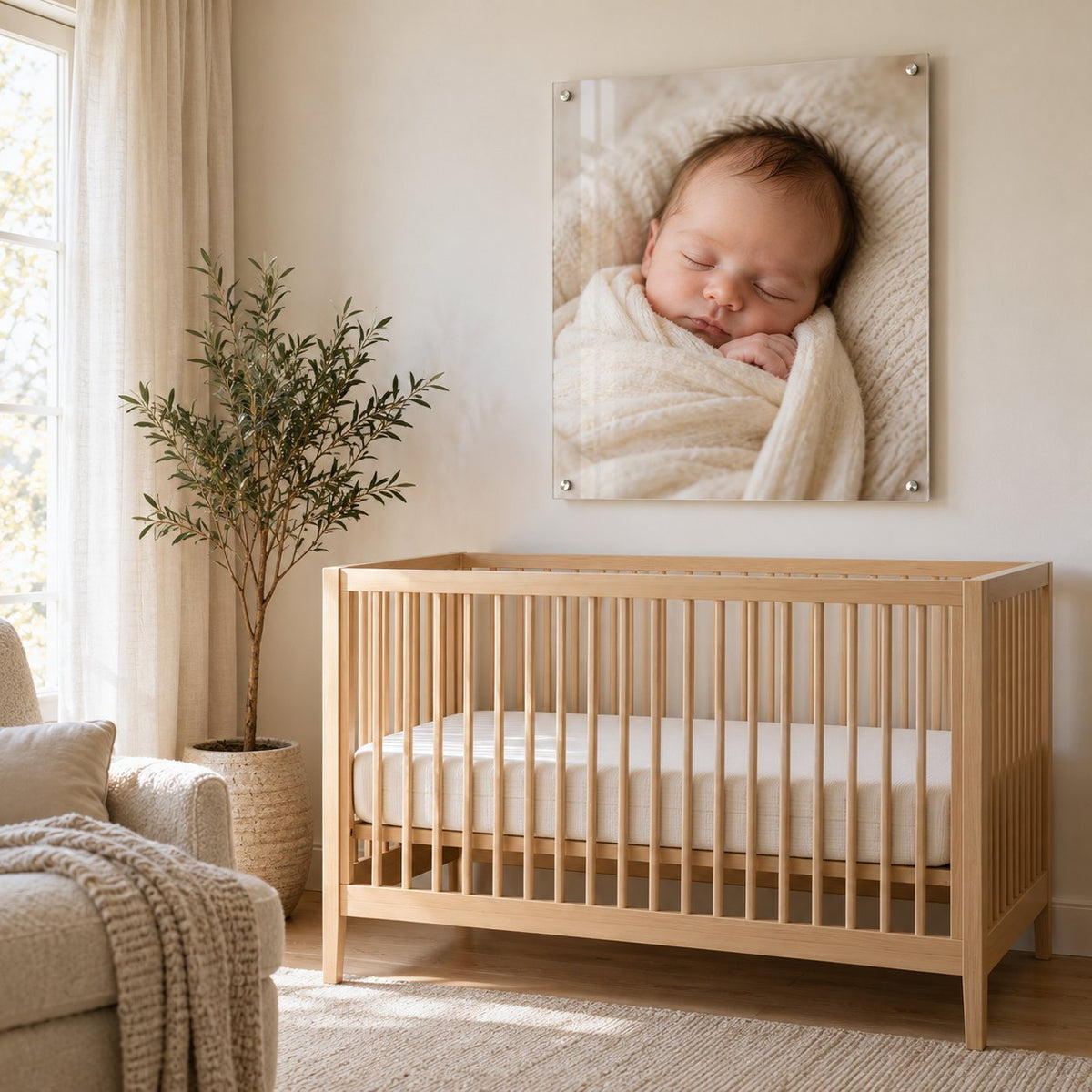 Newborn baby photo printed on clear acrylic with standoffs, hung above a wooden crib in a neutral nursery
